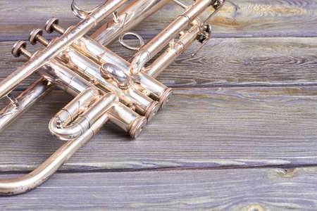 Vintage trumpet and copy space. Old musical instrument on wooden background. Retro jazzy equipment.の写真素材