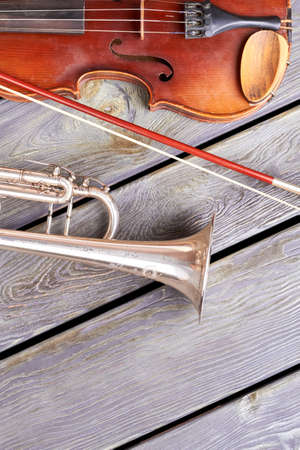 Antique violin and trumpet on wooden floor. Artistic musical instruments and copy space. Create your music.の写真素材