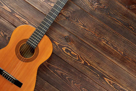 Acoustic guitar on textured wooden background. New ukulele and copy space. Traditional musical...