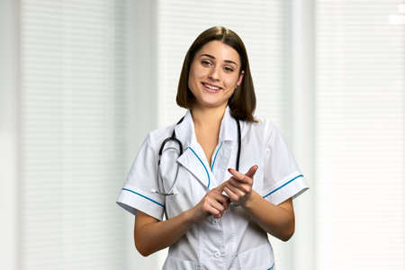 Young smiling doctor talking to camera. Happy female doctor with stethoscope prescribing medicine to...