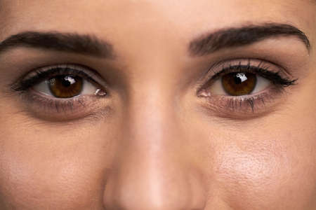 Face of pretty girl close up. Beautiful female eyes of hazel color. Brown female eyes.の写真素材