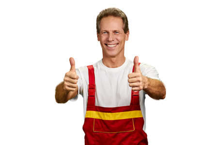 Cheerful smiling engineer showing thumbs up. Happy contractor smiling and showing thumbs up over white background. Symbol of success.の写真素材