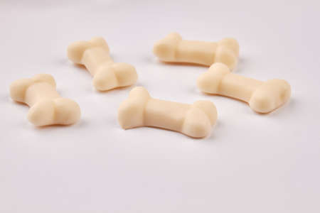 Sweet jelly bones on light background. White gummy candies in a shape of bones. Tasty gelatin...