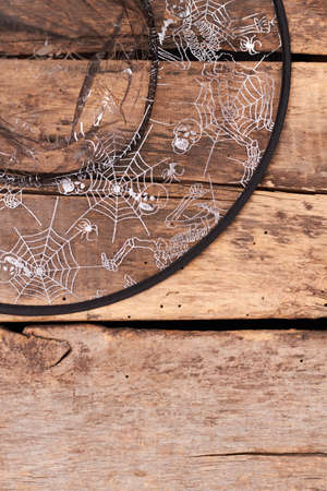 Transparent witch or wizard hat. Witch hat with skeleton patterns on old wooden background with copy...