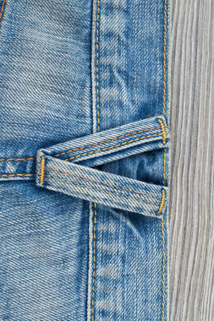 Blue jeans texture back side. Part of denim jeans with seams on wooden background, vertical image.の写真素材