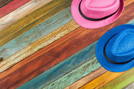 Summer hats on colored wooden background. Blue and pink hats with copy space. Stylish beach accessory.の写真素材