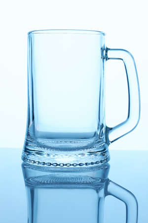 Empty beer glass mug, close up. White isolated background. Blue lighting.の写真素材