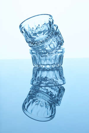 Glass cups and shadow. Blue lighting. Reflective surface.の写真素材