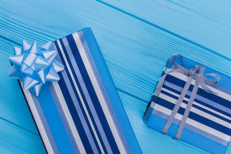 Two striped blue present boxes. Blue wooden background. Top view.の写真素材