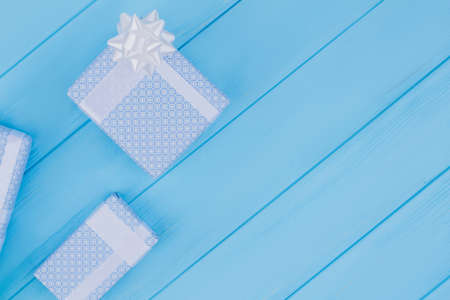 Printed pattern gift boxes. Copyspace. Blue wood background.の写真素材