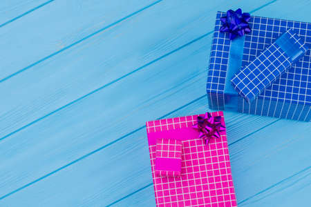 Colorful gift boxes. Pink and blue present for birthday. Copyspace, blue wooden backgroud.の写真素材