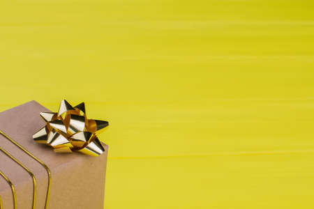 Kraft gift box on yellow background. Yellow wood. Close up.の写真素材