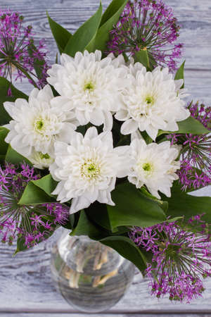 Luxury bouquet of fresh flowers. White chrysnathemums and purple allium background. Holiday greeting card.の写真素材