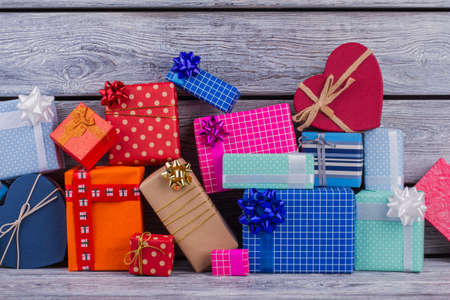 Pile of colorful gift boxes on wooden background. Heap of multicolored present boxes. Holiday greeting concept.の写真素材
