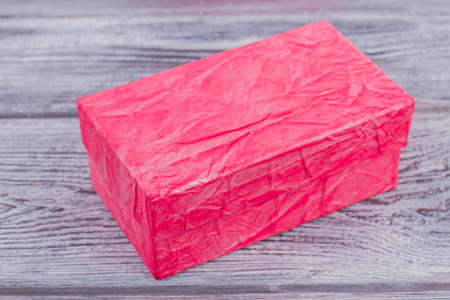 Closed pink gift box on wooden background. Luxury present box on vintage wooden background. Birthday or Valentines day gift.の写真素材