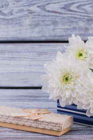 Jewelry gift box and flowers. Valentine holiday background with elegant jewellery gift box and bouquet of white chrysanthemums. Holiday present concept. Womens Day background.の写真素材