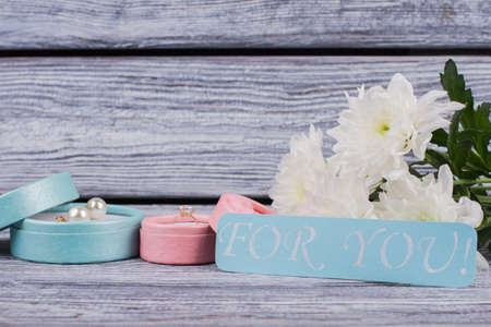 Romantic background with flowers and jewellery. Diamond ring, pearl earrings and chrysanthemums....