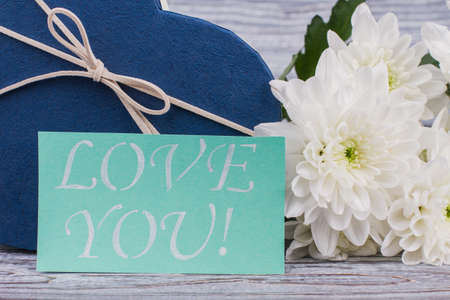 Valentines Day surprise concept. Close up flowers, gift box and card with inscription love you....