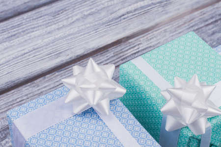 Holiday gifts on wooden background. Wedding present boxes with white bow. Holiday celebration...