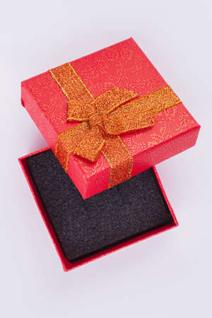 Blank red gift box isolated. Beautiful present box with golden bow. Gift box for jewelry.