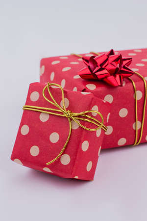 Gift boxes wrapped in fashion design paper. Present boxes in red dotted paper with bow. Christmas...