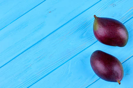 Whole healthy mangoes on colorful wooden surface with text space, top view.の写真素材
