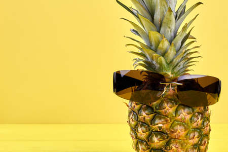 Fresh juicy pineapple fruit wearing sunglasses with dark glass.の写真素材