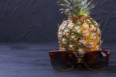 Hawaiian pineapple and sunglasses on dark background.の写真素材