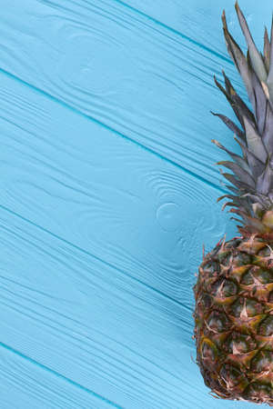 Tasty exotic pineapple fruit on blue wooden surface and text space.の写真素材