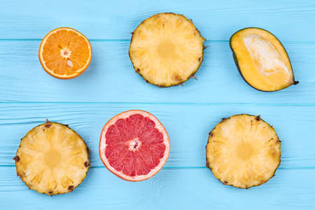 Freshly sliced exotic fruits on color wooden surface.の写真素材
