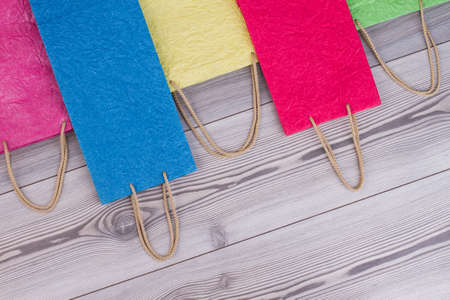 Rope handles colored paper gift bags. Crumple paper colorful shopping bags with copy space. Buy...