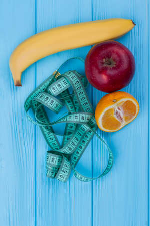 Top view on measuring tape and fresh fruits. Health care and healthy food concept. Healthy eating...