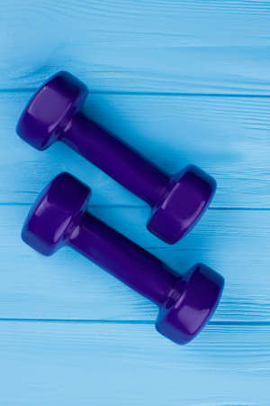 Pair of dumbbells, top view. Hand weights on wooden background. Equipment for gym workout.