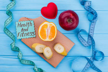Measuring tape and fruits on color background. Health and fitness. Health food trends. Make healthy choice.の写真素材