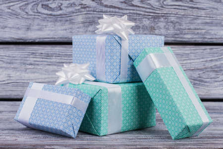 Group of gift boxes on wooden background. Present boxes wrapped with blue and turquoise paper on...