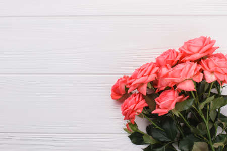 Bunch of pink rose flowers. White wooden desk background.の写真素材