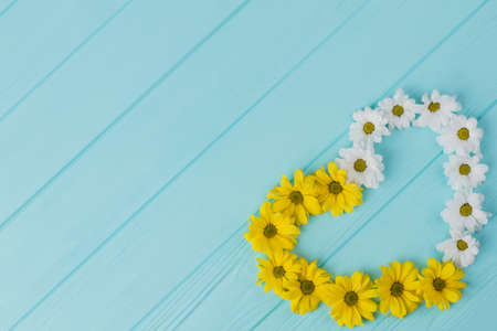 Flowers, heart-shaped composition. Top view, copyspace. Blue wood background.の写真素材