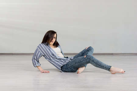 Beautiful young girl practicing dance element. Cute caucasian girl dancer posing on studio background. School of dance art.の写真素材