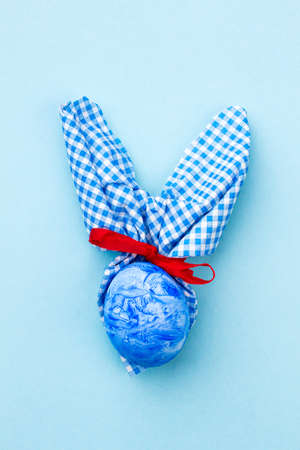 Easter rabbit on blue background. Blue Easter bunny made from egg and napkin. Idea of Easter gift.の写真素材