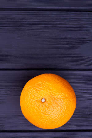 Orange fruit on dark wooden table. Ripe orange citrus fruit on black wooden background with copy space on top.の写真素材