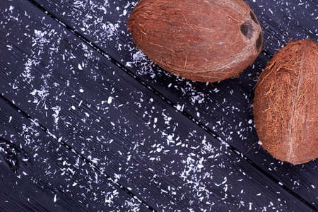 Two ripe appetizing coconuts, top view. Two exotic coconuts, coconut flakes and copy space. Fresh...