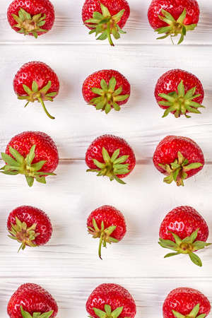 Rows of ripe strawberries on wooden surface. Organic sweet strawberries in rows as a seasonal...