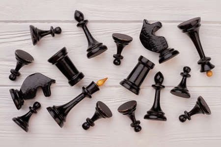 Black chess pieces lying on white background. Group of black chess figures on white wooden table.の写真素材