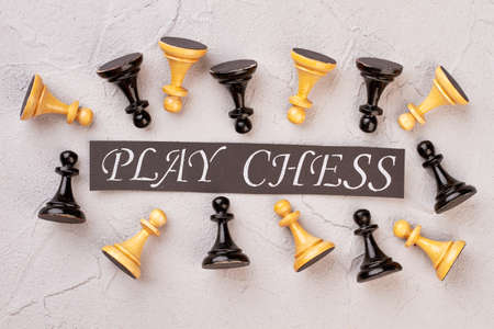 Composition of black and white chess pieces. Collection of chess pawns and card with inscription...