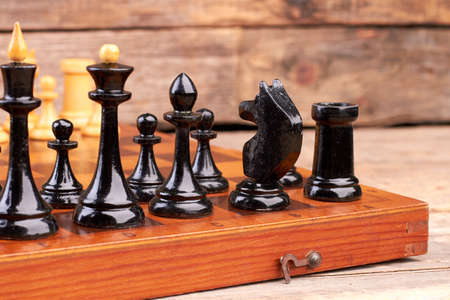 Black chess pieces on chess board. Set of chess figures placed on chess board, cropped image. Game...