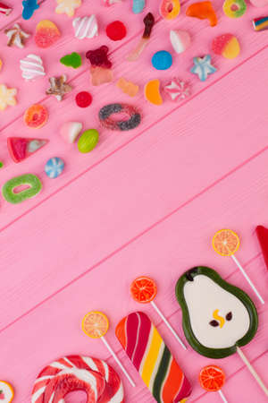 Sweets and candy creative lay out. Flat lay composition with delicious colorful candies and space for text on color background.の写真素材