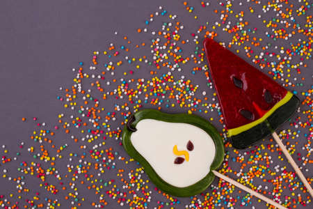 Large tasty lollipops on black background. Composition with lollypops and colored candies. Creative...