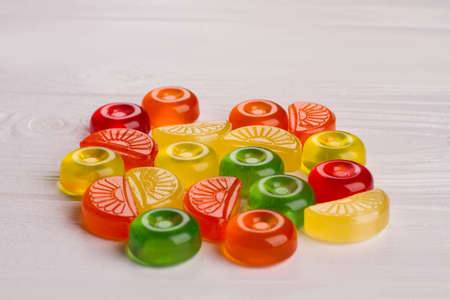 Many colorful candies on white background. Delicious multicolored sweets on white wood table.の写真素材