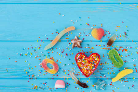 Holiday background with various candies and sweets. Composition from candies on blue wooden...