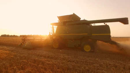 Side view of moving combine. Commercial grain farming.